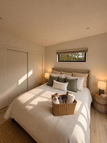 a bedroom with a large bed with a basket on it at The palms farmhouse in Puketona