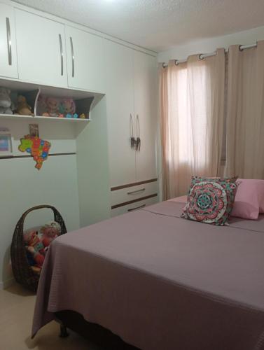 a bedroom with a bed and a basket and cabinets at Small family apartment in Sao Sebastiao