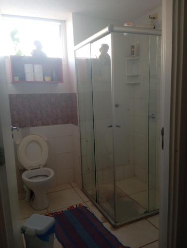 a bathroom with a glass shower and a toilet at Small family apartment in Sao Sebastiao