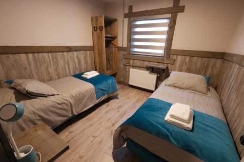 a bedroom with two beds and a window at Casa Oxidada in Puerto Natales