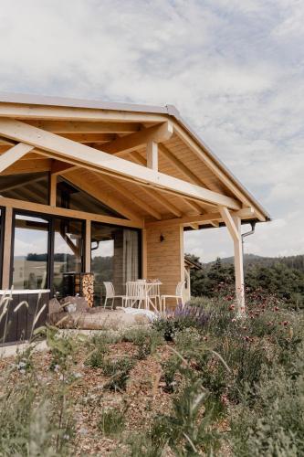 a house with a wooden roof with a table and chairs at Hüttenchalets Rhön in Geisa