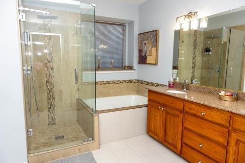 a bathroom with a shower and a tub and a sink at Bluebonnet Retreat in Flower Mound