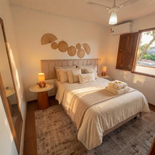 a bedroom with a large bed and a window at Residência Thomas in Itacaré