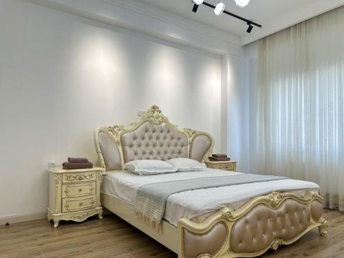 a bedroom with a gold bed and two night stands at Tashkent city Gardens E2 block in Tashkent