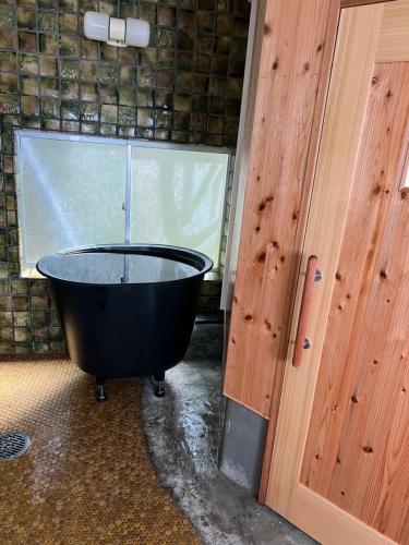 a black bath tub in a room with a window at ASTERISK＋ in Iwami