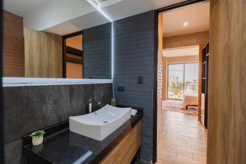 a bathroom with a white sink and a black wall at TORRE ARCARTI Internet alta velocidad y estacionamiento in San Baltasar