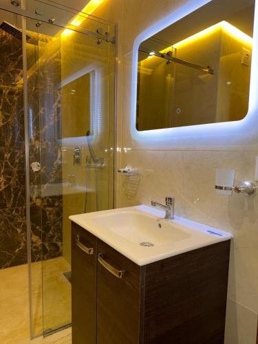 a bathroom with a sink and a shower with a mirror at Triple Tower 23eme étage La vue 329 gare tgv & plage 3min in Tangier