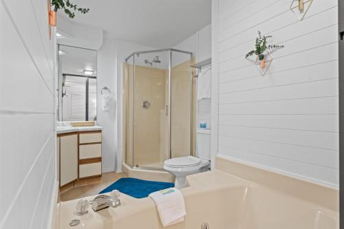 a white bathroom with a tub and a toilet at Dells Suite Dreams At Lighthouse Cove Condominiums in Wisconsin Dells