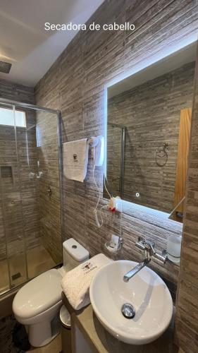 a bathroom with a sink and a toilet and a shower at OXALAND HAUs in Oxapampa