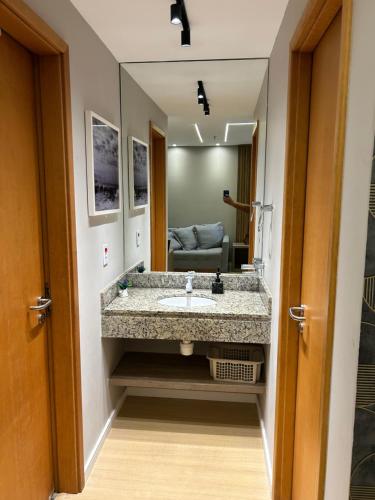 a bathroom with a sink and a large mirror at Flat Completo no Centro de Itaboraí Promenade Prime in Itaboraí