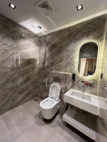 a bathroom with a toilet and a sink and a mirror at Janjua lodges Murree in Murree