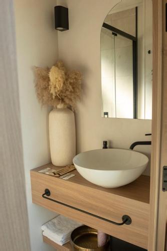 a bathroom with a white sink and a mirror at L'Instant Des Amants in Sorèze