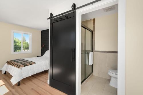 a bathroom with a sliding door leading to a bed at The Central Block Bend Motel in Bend