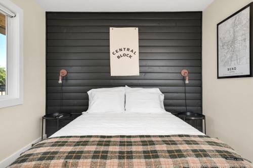 a bedroom with a large bed with a black headboard at The Central Block Bend Motel in Bend