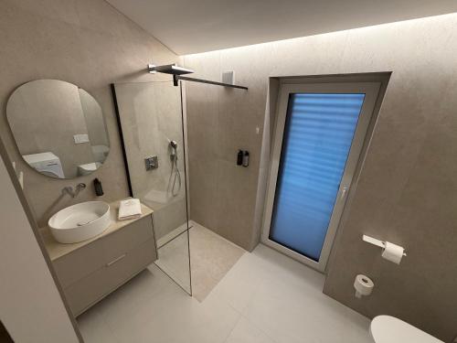 a bathroom with a sink and a mirror and a shower at Vista on the sea in Ankaran