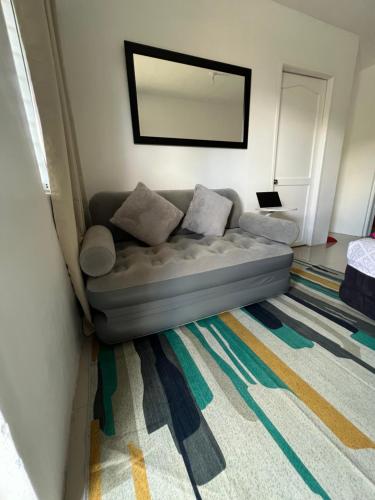 a couch in a living room with a mirror at Alexeis Place in Manolo Fortich