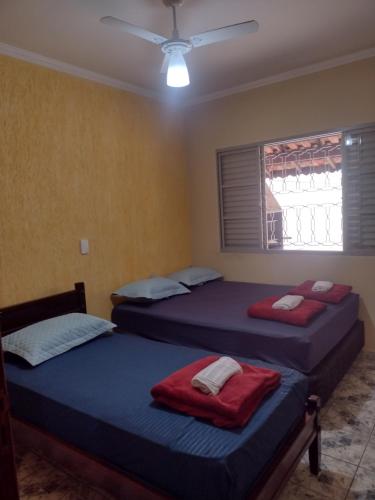 a bedroom with two beds and a ceiling fan at Casa na área central com 3 quartos in São Pedro