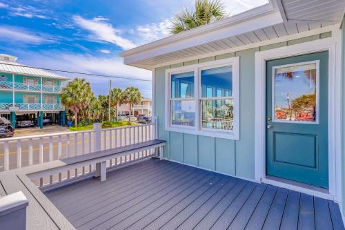 a house with a blue door and a bench on a deck at Hazel Q in Edisto Island