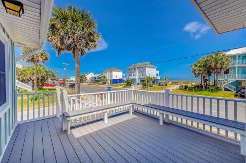 a porch with a bench and a palm tree at Hazel Q in Edisto Island