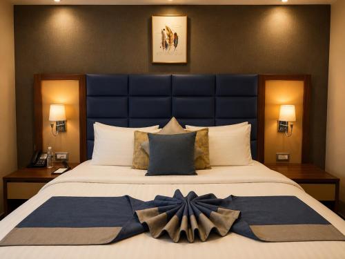 a bedroom with a large bed with a large blue headboard at Smart Gate Hotel Apartments سمارت غيت للشقق الفندقية in Jazan