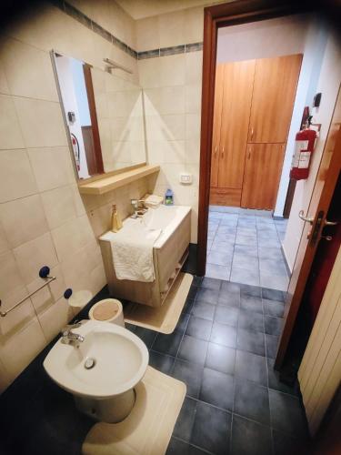 a bathroom with a sink and a tub and a toilet at Salento Garden Relax in Merine