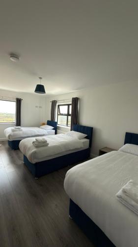 a bedroom with three beds in a room at Dwellinghouse, Inishmore in Ourtnagapple