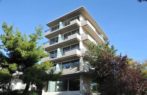 an apartment building with trees in front of it at Elements Rooms & Apartments in Athens