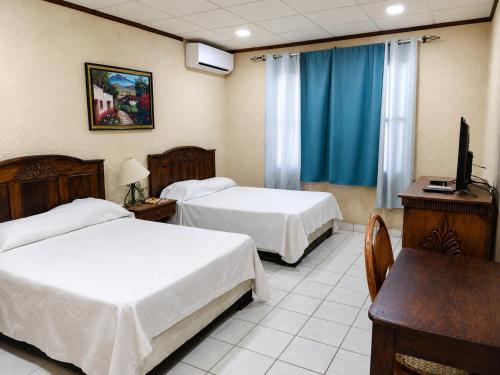 a hotel room with two beds and a television at Hotel La Estacion in La Unión