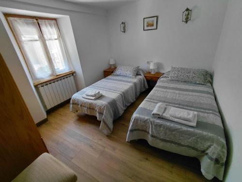 a bedroom with two beds and a window at Pension pedebaile in Vilac