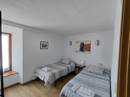 a room with two beds and a window at Pension pedebaile in Vilac