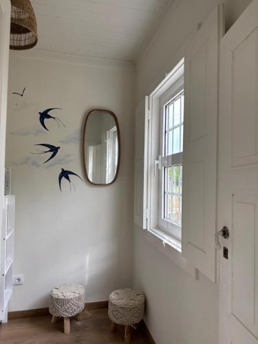a room with a mirror and birds on the wall at Valadouro Dona Adelaïde With a Pool in Espinhosa
