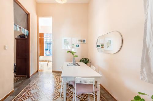 a room with a white table and chairs and a mirror at Casa Donderis in Santo Domingo