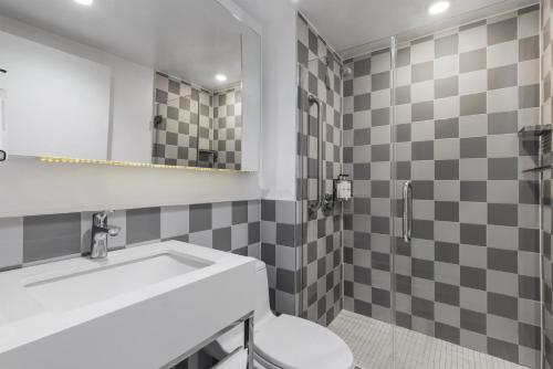 a bathroom with a sink and a toilet and a mirror at Best Western Premier Empire State Hotel in New York
