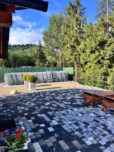 a patio with a table and a bench and a fence at Chalet Tukhlya in Tukhlya