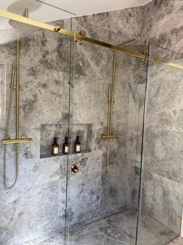 a shower with a glass door and lights in a bathroom at Villa Ljeto in Pupnatska Luka