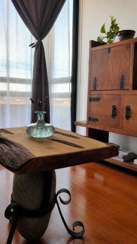 a wooden table with a vase on top of it at Acogedor departamento en La Serena in La Serena