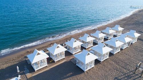 une rangée de bâtiments blancs sur la plage dans l'établissement Alice Hotel Antalya, à Lara