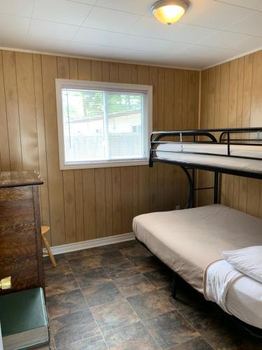 a room with two bunk beds and a window at Wu Wu's Cabins in Wasaga Beach