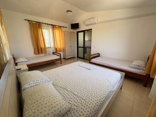 a room with three beds in a room at Hasler Studios in Qerret