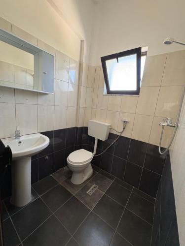 a bathroom with a toilet and a sink and a window at Hasler Studios in Qerret