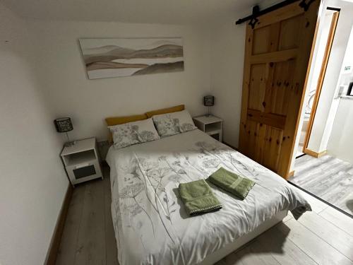 a bedroom with a bed with two green towels on it at Stardust Getaway Tiny-Home E32AK40 in Piltown