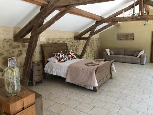 a bedroom with a bed and a couch at Gîte La Carole 120m2 in Monlezun