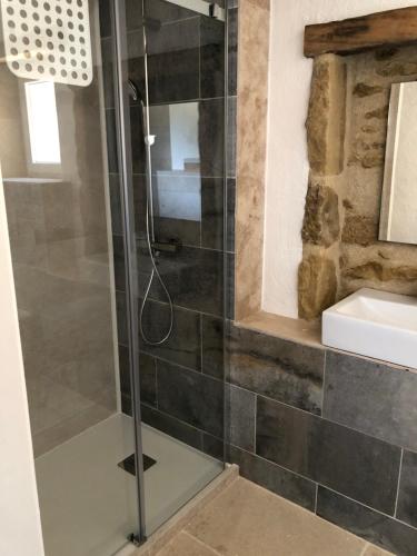 a shower with a glass door in a bathroom at Gîte La Carole 120m2 in Monlezun