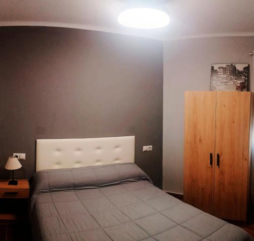 a bedroom with a bed and a wooden cabinet at Apartamento El Centro in Algarrobo