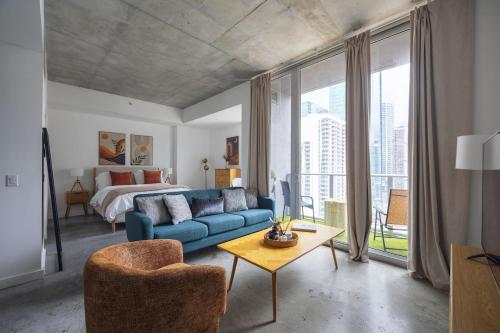 a living room with a blue couch and a bed at Chic Studio by Brickell & Miami Beach WD Pool Gym in Miami