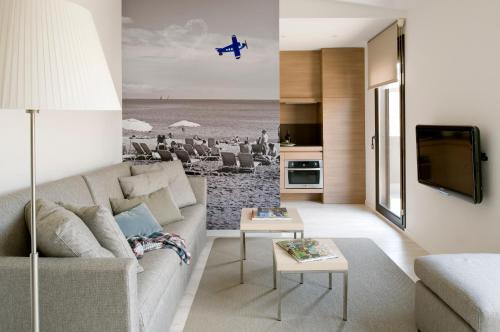 a living room with a couch and a view of a beach at Eric Vökel Boutique Apartments - BCN Suites in Barcelona