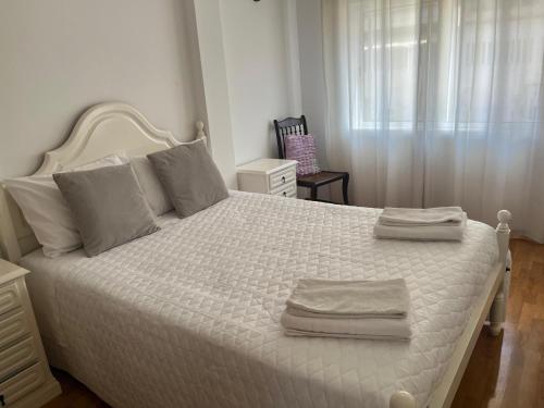 a bedroom with a white bed with two towels on it at Ancoravilla in Vila Praia de Âncora