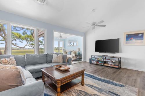a living room with a couch and a tv at 1211 Creekwatch Villa in Seabrook Island