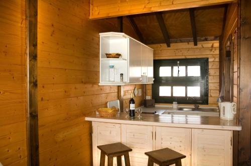 a kitchen with wooden walls and a counter with stools at Apartamentos Santa Ana - Adults Only in Playa de Santiago