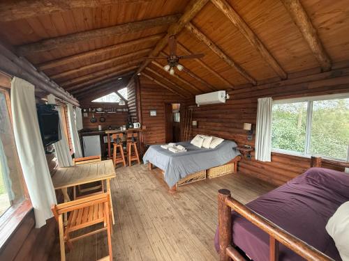 a bedroom with a bed in a log cabin at Cabañas Los Troncos in San Pedro